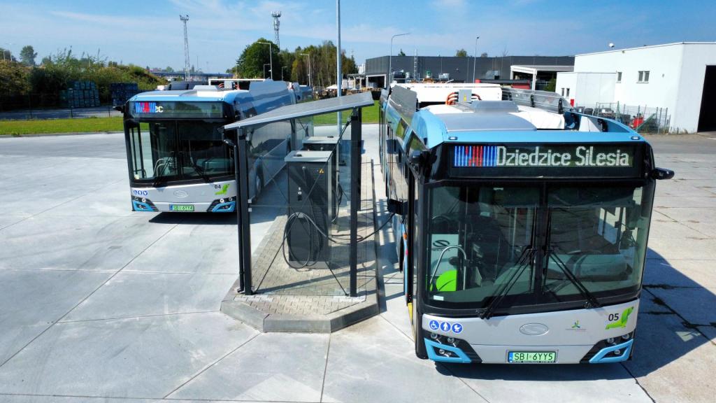 dwa autobusy elektryczne zaparkowane przy ładowarce