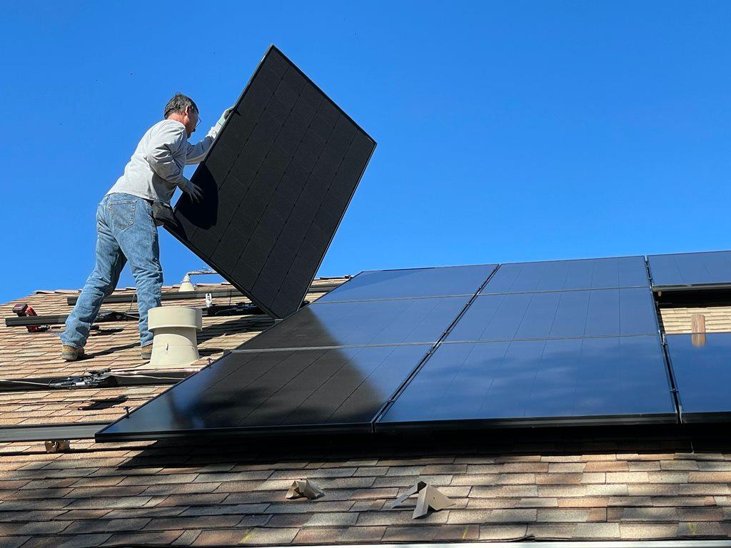 instalator układa panele pv na dachu