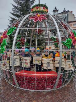 dzieci stojące w bombce - ozdobie świątecznej