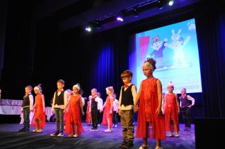 Występ grupy przedszkolaków w czerwonych strojach
