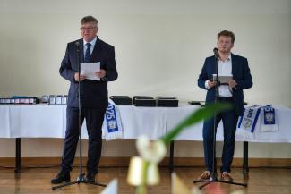 przemawiający do mikrofonu mężczyzna