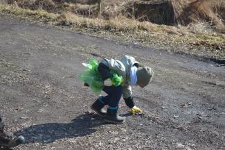 chłopiec podnoszący śmieci