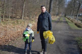 mężczyzna z dzieckiem zbierający śmieci