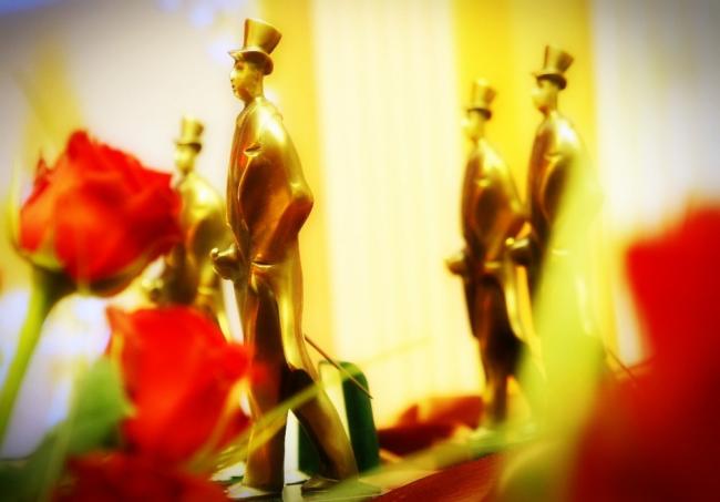 Statuetki Czechosława na tle kwiatów